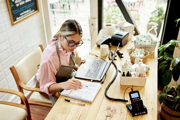 business owner using laptop in retail shop