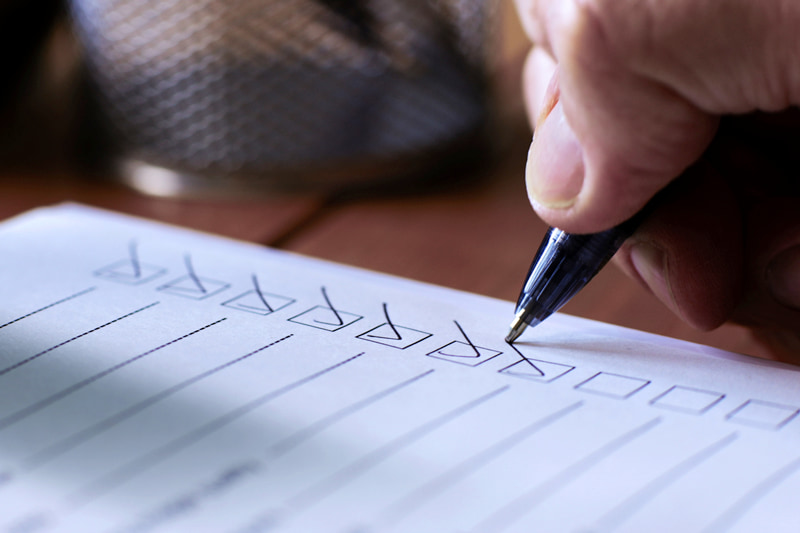 hand using pen checking items off a checklist