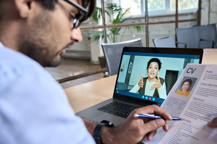 human resource manager holding cv during remote interview