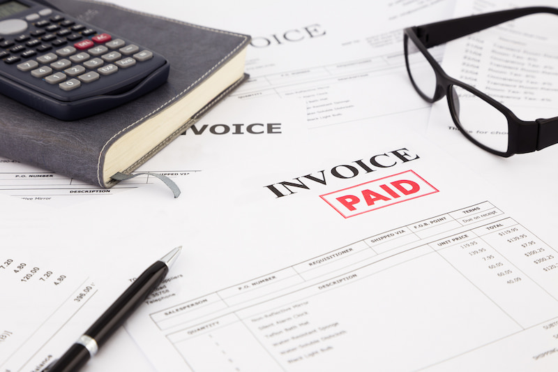 paper invoice with red 'paid' stamp